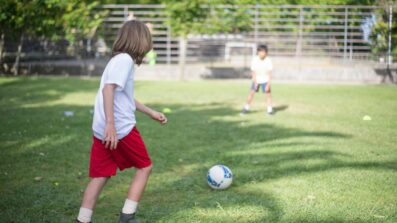 children playing football at school on field